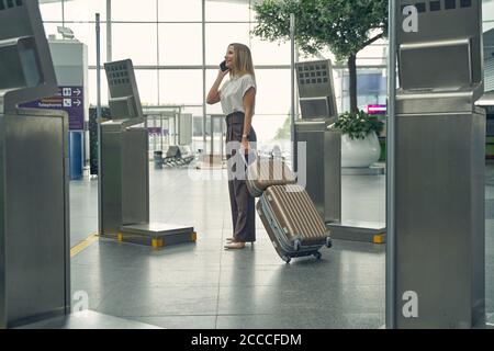 Felice giovane donna che controlla arrivo e partenza monitor Foto Stock