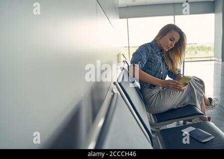 Concentrata giovane donna che controlla i suoi messaggi di reddito Foto Stock