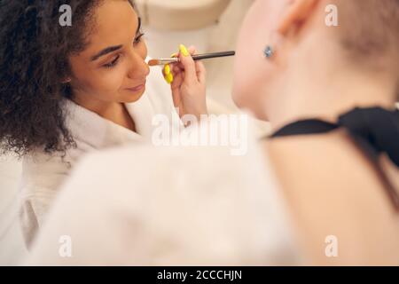 Bella donna afro americana frequentando il trucco artista Foto Stock