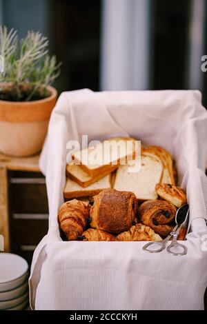 Primo piano di pane, panini e croissant in un cestino di pane. Foto Stock