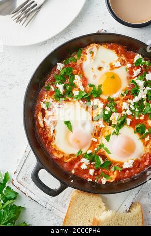 Shakshouka, uova in camicia in salsa di pomodori, olio d'oliva. Cucina mediterranea. Foto Stock