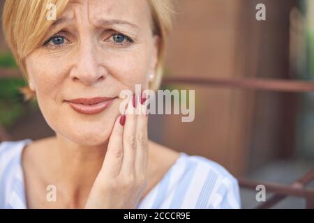 Bella donna triste che sta davanti a lei Foto Stock