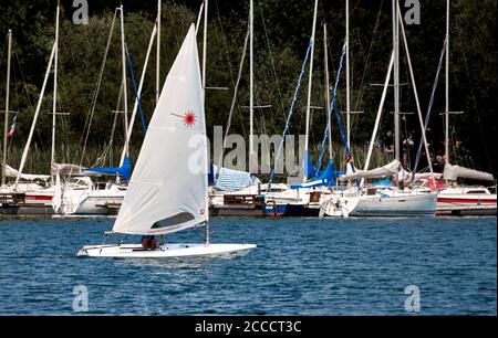 Gifhorn, Germania, 9 agosto 2020: Piccole crociere agili in barca a vela veloce di fronte al molo con imbarcazioni da diporto Foto Stock