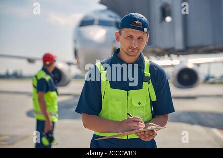 Uomo che tiene in mano una clipboard Foto Stock