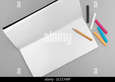 Spazio per copie artistiche con notebook di lusso, matita e pastello multicolore, vista dall'alto Foto Stock