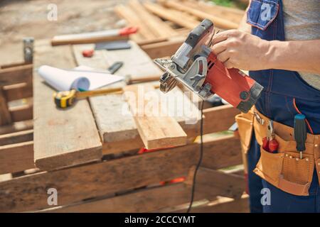 Builder pronto per il taglio del legno all'aperto Foto Stock