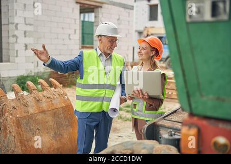 Sorridente lavoratore che punta a qualcosa in lontananza Foto Stock