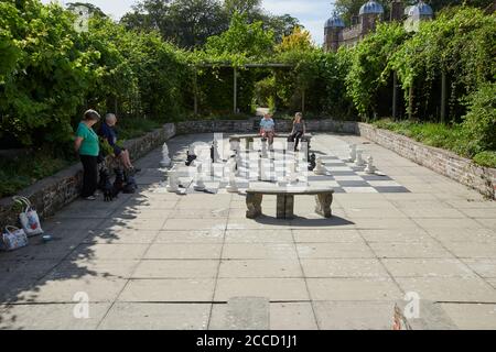 Un gruppo di famiglie che ama gli scacchi all'aperto in un giardino murato, East Yorkshire, Inghilterra, Regno Unito, GB. Foto Stock