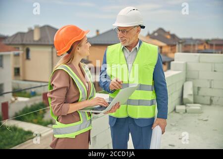 Bionda femmina contrattista sorridente ad un ingegnere civile Foto Stock