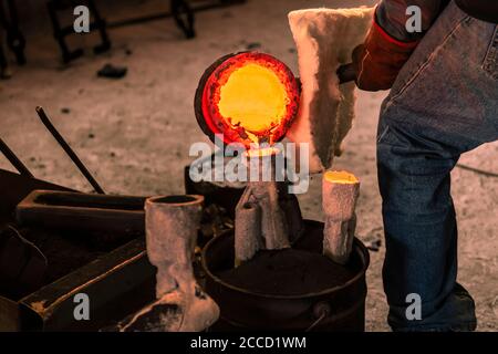 Fusione del bronzo in piccola fonderia. La sequenza di immagini mostra il processo di fusione completo, dalla fusione di lingotti alla rottura del guscio ceramico di una scultura. Foto Stock