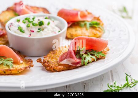 Frittella di patate con prosciutto e salsa di ravanelli, formaggio cremoso e erba cipollina. Concetto di cibo sano. Foto Stock