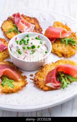 Frittella di patate con prosciutto e salsa di ravanelli, formaggio cremoso e erba cipollina. Concetto di cibo sano. Foto Stock