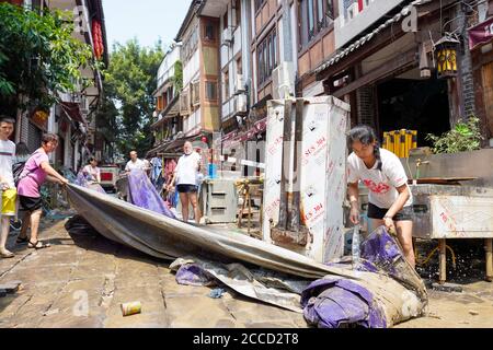 Chongqing, comune cinese di Chongqing. 21 Agosto 2020. La gente pulisce i negozi e la strada nella città antica di Ciqikou, la città sudoccidentale di Chongqing, 21 agosto 2020. Gli operatori sanitari, i volontari e i residenti locali hanno iniziato a pulire e disinfettare l'antica città mentre le acque alluvionali hanno cominciato a recedersi a Chongqing. Credit: Liu Chan/Xinhua/Alamy Live News Foto Stock