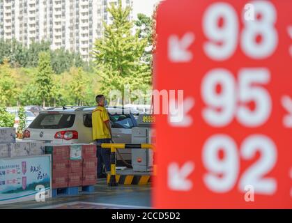 Hanan, Hebei della Cina. 21 Agosto 2020. Un membro del personale riempie il serbatoio di un'auto presso un distributore di benzina a Handan City, Hebei della Cina settentrionale, 21 agosto 2020. La Cina aumenterà i prezzi al dettaglio della benzina e del diesel a partire da Sabato, la Commissione Nazionale per lo sviluppo e le riforme ha detto Venerdì. Il prezzo della benzina salirà di 85 yuan (circa 12.3 dollari USA) per tonnellata, mentre quello del diesel aumenterà di 80 yuan. Credit: Li Hao/Xinhua/Alamy Live News Foto Stock