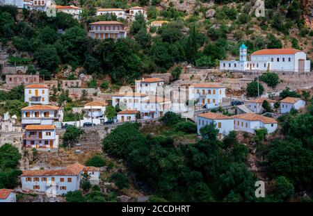 Vuno/Albania – 7 agosto 2020: Vista del villaggio - tradizionali case bianche con tetti arancioni e persiane in legno su finestre - sulla montagna hil Foto Stock