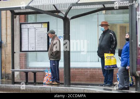 Bagnati e cupi iniziano la giornata per i membri del pubblico nel centro di Oldham, che si trova sul bordo della serratura. Foto Stock