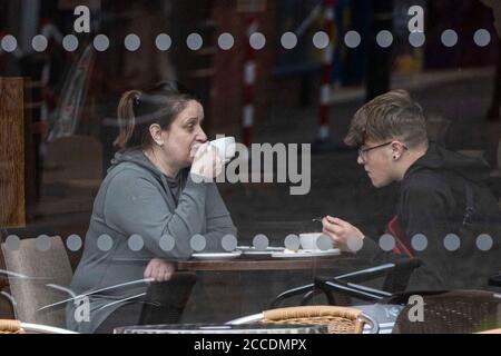 Bagnati e cupi iniziano la giornata per i membri del pubblico nel centro di Oldham, che si trova sul bordo della serratura. Foto Stock