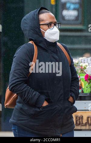 Bagnati e cupi iniziano la giornata per i membri del pubblico nel centro di Oldham, che si trova sul bordo della serratura. Foto Stock