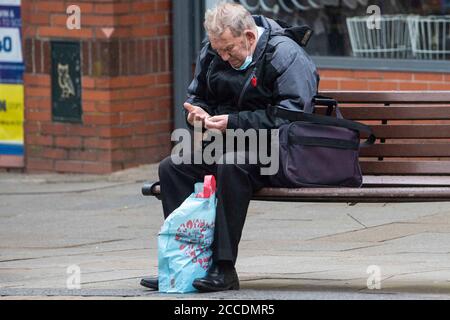 Bagnati e cupi iniziano la giornata per i membri del pubblico nel centro di Oldham, che si trova sul bordo della serratura. Foto Stock
