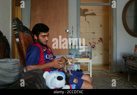 Beirut, Libano. 21 Agosto 2020. Anthony tende il suo animale ferito Sooshi a casa sua nella devastata zona di Mar Mikhail a Beirut. Più di due settimane dopo la massiccia esplosione portuale del 4 agosto alcuni residenti hanno iniziato a tornare a casa per la pulizia, la riparazione e per cercare di tornare alla loro vita normale. Credit: Marwan Naamani/dpa/Alamy Live News Foto Stock