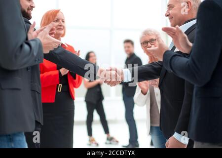 Uomini d'affari rendendo stretta di mano in un ufficio. Foto Stock