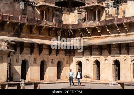 Orchha, Madhya Pradesh, India - Marzo 2019: Due turisti indiani maschi a piedi all'interno del complesso antico palazzo di Jehangir Mahal nel Forte di Orchha. Foto Stock