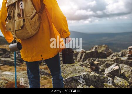 uomo in camice giallo in piedi sulla cima della montagna guardando la distanza. primo piano foto ritagliata Foto Stock