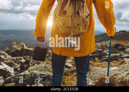 Immagine ritagliata di una passeggiata turistica lungo il sentiero escursionistico con secchio. Primo piano indietro vista ritagliata foto Foto Stock