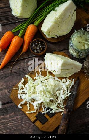 Sauerkraut preservando lo sfondo. Crauti fatti in casa con carote al pepe nero su rustico tavolo in legno. Cibo fermentato. Foto Stock