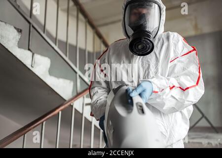 Disinfettante in tuta protettiva per la disinfezione in aree contaminate. Disinfettante professionale contro COVID-19, coronavirus. In tuta da vestiario Foto Stock