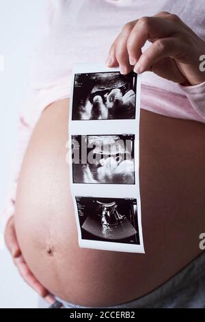 Donna incinta che tiene le scansioni del bambino Foto Stock