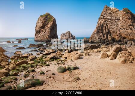 Rocce a Ursa spiaggia, Sintra, Portogallo. Epico catapasta di mare che torreggia sulla costa dell'oceano atlantico illuminata da una luce calda serale. Foto Stock