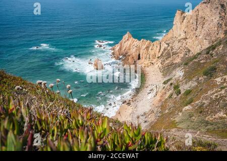 Spiaggia di Praia do Ursa con splendide scogliere color arancio sulla costa dell'oceano Atlantico. Popolare vacanza viaggio posizione turistica in Portogallo. Foto Stock