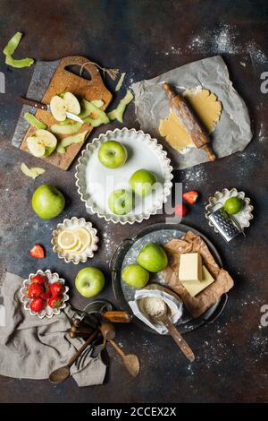 Varietà di prodotti alimentari sul tavolo da cucina. Processo di creazione di torta, vista dall'alto. Foto Stock