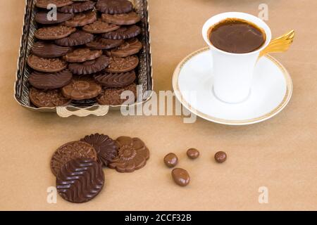 Cioccolato Madlen in vassoio d'argento vintage su sfondo di carta kraft con caffè Foto Stock