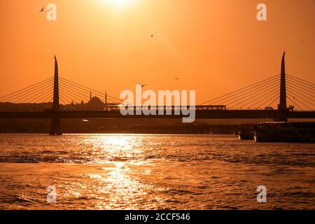 Il Ponte della Metropolitana del Corno d'Oro che attraversa il Corno d'Oro con la Moschea del Sultano Selim di Yavuz sullo sfondo al tramonto. Istanbul. Turchia Foto Stock