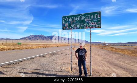 Il turista si trova di fronte all'insegna della Extraterrestre Highway, Nevada USA Foto Stock