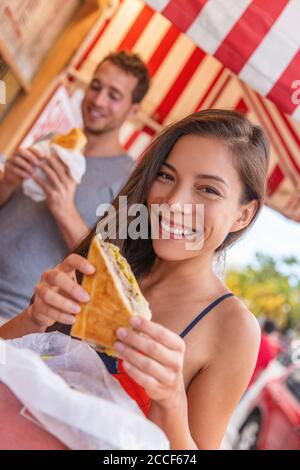 Happy Asian girl che mangia un panino cubano al ristorante locale di Key West, Florida. Estate viaggio turistico stile di vita giovane donna asiatica sorridente mangiare Foto Stock