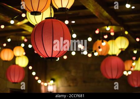 Primo piano su colorate lanterne cinesi tradizionali appese al soffitto. Sfondo a fuoco bello e morbido Foto Stock