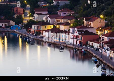 Case e barche da pesca nel porto di Vathy villaggio in Ithaca. Foto Stock