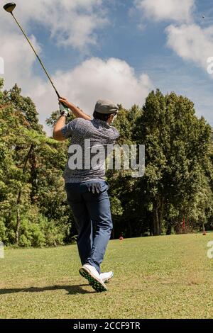 Un uomo che vola attraverso l'aria su un campo da golf. Foto di alta qualità Foto Stock