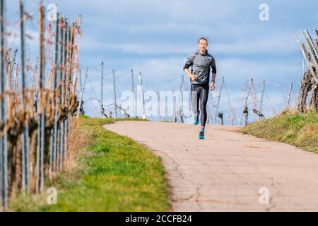 Uomo, 30 anni, jogging a Kappelberg, Remstal, Baden-Württemberg, Germania Foto Stock