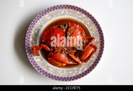 Granchio in salsa Padang o granchio Padang (indonesiano: Kepiting saus Padang) su sfondo bianco. Foto Stock