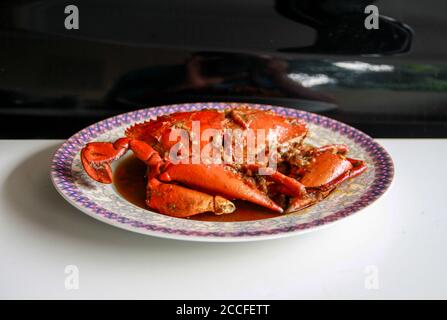 Granchio in salsa Padang o granchio Padang (indonesiano: Kepiting saus Padang) su sfondo nero. Foto Stock