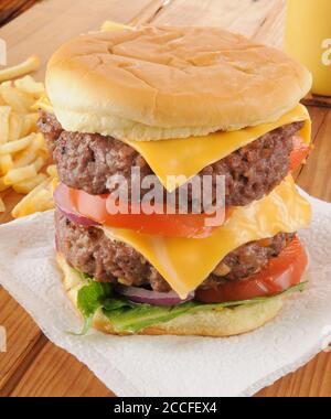 Un grande cheeseburger a due piani con patatine fritte Foto Stock