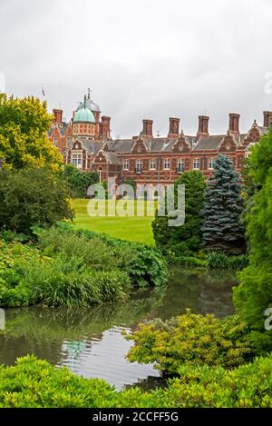 I giardini e il grande lago sul retro di Sandringham House, una casa di campagna vittoriana classificato di grado II*, situata su 20,000 acri di terreno vicino al vile Foto Stock