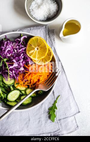 Salutare concetto di insalata con verdure crude e fresche in un ciotola su fondo di cemento Foto Stock