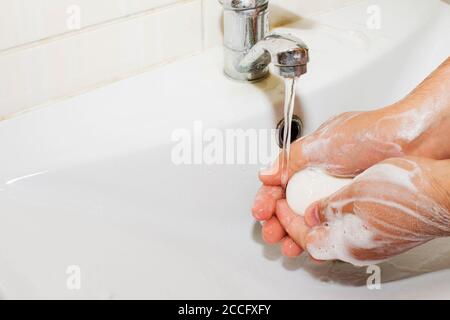 lavabo e acqua corrente dal rubinetto in bagno Foto Stock