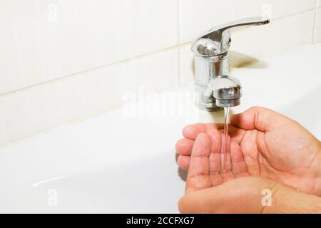 lavabo e acqua corrente dal rubinetto in bagno Foto Stock