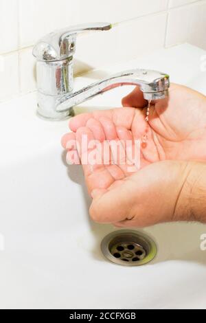 lavabo e acqua corrente dal rubinetto in bagno Foto Stock